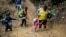 ARCHIVO: Migrantes con niños atraviesan la selva del Darién rumbo a Panamá en su ruta hacia Estados Unidos, el 15 de octubre de 2022. (AP Foto/Fernando Vergara, Archivo)