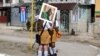 Estudiantes con una fotografía de Fidel Castro esperan en Buenaventura, Cuba, el 2 de diciembre de 2016, cuando una caravana con sus cenizas recorrió la isla hasta depositarlas en Santiago de Cuba.