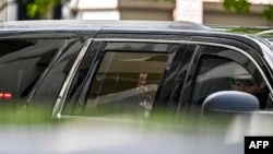 El ex presidente Donald Trump saluda desde el auto que le conduce por las calles de Miami.