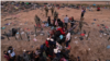 Migrantes intentan cruzar una valla de alambre de púas desplegada para impedir el cruce de migrantes a EEUU, a orillas del río Bravo, en la frontera con México.