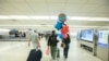 Foto de archivo. Una familia en el Aeropuerto Internacional de Miami. Foto: Alexia Fodere para Voz de América.