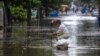 Un vecino destupe una alcantarilla en una calle inundada de El Vedado. (Facebook Canal Caribe)