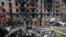 Trabajadores de los servicios de emergencias inspeccionan los daños causados en un edificio de varias plantas por un ataque ruso, en Krivói Rog, Ucrania, el 13 de junio de 2023. (AP Foto/Andriy Dubchak)