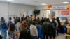 ARCHIVO - Varias personas hacen fila en el centro de bienvenida a migrantes frente a la estación de autobuses, el viernes 16 de diciembre de 2022, en Brownsville, Texas