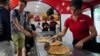Yousy Oliva sirve pizza a los clientes en un restaurante privado en La Habana, el 16 de agosto de 2023. (REUTERS/Alexandre Meneghini)