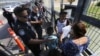 Oficiales de Aduanas y Protección Fronteriza de EE. UU. revisan los documentos de migrantes en el Puente Internacional 1 en Nuevo Laredo, México. (AP/Marco Ugarte/Archivo)