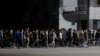 Agentes de civil, armados con palos, se dirigen a reprimir una protesta pacífica en La Habana, durante un apagón el 30 de septiembre de 2022.