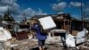 Un residente lleva a cuestas una lavadora dañada después del paso del huracán Ian en Cuba en 2022 / Foto: Yamil Lage (AP)