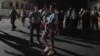 Una madre cubana carga a su hijo durante una manifestación en noviembre de 2022 que fue reprimida por tropas paramilitares y policías.
(REUTERS/Alexandre Meneghini).