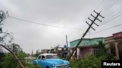 Un automóvil antiguo pasa por los escombros causados por el huracán Ian a su paso en Pinar del Río, Cuba.
