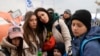 Una familia de refugiados espera en una fila en el paso fronterizo de Medyka, en el sureste de Polonia, tras huir de la guerra de la vecina Ucrania . (AP Foto/Sergei Grits