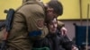 Un soldado consuela a Larysa Kolesnyk, de 82 años, luego de que fuera evacuada de Irpín, en las afueras de Kiev, Ucrania.