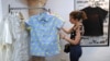 Clienta valorando la ropa de tienda Clandestina, uno de los negocios privados más exitosos de la isla.