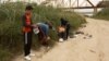Un grupo de migrantes de Cuba revisa sus teléfonos poco después de cruzar el Río Grande en Eagle Pass, Texas, el 18 de diciembre de 2022.