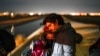 Una pareja de Cuba espera ser procesada para solicitar asilo después de cruzar la frontera cerca de Yuma, Arizona. (AP/Gregory Bull)