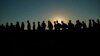 Migrantes que cruzaron el Río Grande y entraron a EEUU desde México hacen fila para ser procesados por la Oficina de Aduanas y Protección Fronteriza estadounidense. (AP/Eric Gay, File)