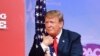 El presidente Donald Trump abraza la bandera de los EEUU, momentos antes de hablar en la Conferencia anual de Acción Política Conservadora (CPAC) en National Harbor, Maryland, el 2 de marzo de 2019.