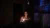 Una joven sostiene una vela en medio del apagón, en La Habana, Cuba. (YAMIL LAGE / AFP)