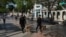 Boinas negras con perros recorren el Paseo del Prado en el primer aniversario del estallido del 11 de julio.