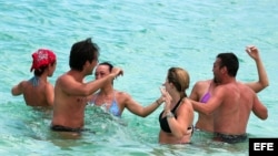 Grupo de turistas bailando en una playa de La Habana (Cuba).