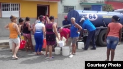 Vecinos de Santiago de las Vegas, en Boyeros hacen cola frente a una pipa de agua.