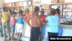 Residentes hacen fila para adquirir alimentos racionados en una bodega de Holguín.