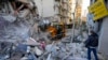 Rescatistas utilizan una excavadora para retirar escombros de edificios destruidos en el lugar de un ataque aéreo israelí el domingo por la noche arias oficinas de entidades financieras de Hezbollah Beirut, Líbano. (AP/Hassan Ammar)