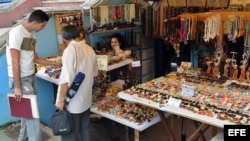 Dos hombres compran artesanías cubanas en La Habana (Cuba).