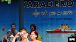 Dos mujeres cubanas hospedadas en hoteles de Varadero, toman fotos con sus cámaras digitales.