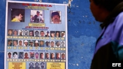 Una persona observa uno de los carteles en el municipio de Monterrey,925 kilómetros de la capital mexicana que ofrecen recompensas de hasta 5 millones de dólares por información que lleve a la captura de el narcotraficante Joaquín Guzmán Loera, alias "El