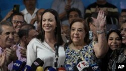 Corina Yoris (der.) saluda a sus seguidores junto a la excandidata de la oposición María Corina Machado.