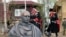 Cosacos rusos con su uniforme posan junto a busto de Putin.