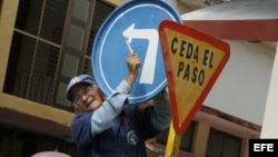 Un hombre instala una señal de tránsito en una calle de la Ciudad de Holguín, Cuba.