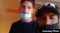 Daniel Llorente (der.) cruza la frontera en Laredo, Texas, junto a su hijo, Eliécer Llorente.