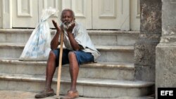 Un anciano permanece sentado en las escaleras del Gran Teatro.