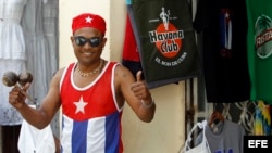 Un joven vestido con los colores de la bandera cubana posa para una foto en una calle de La Habana.