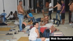 Migrantes cubanos permanecen en una bodega habilitada como albergue temporal, en Turbo, Colombia.