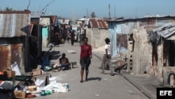 Una mujer caminia por un barrio en Puerto Principe, Haití.