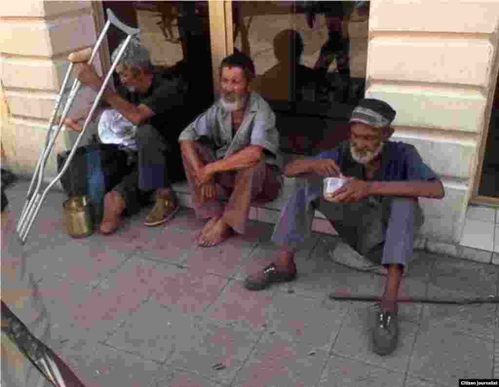 tres indigentes alimentándose en el céntrico boulevard, ubicado en la calle Crombet entre Calixto García y Los Maceos, el que tiene las muletas es un ex combatiente de la guerra de Angola.  