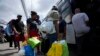 Migrantes de Venezuela abordan un autobús al Aeropuerto Internacional de Tocumen en Ciudad de Panamá, el miércoles 26 de octubre de 2022. (AP Foto/Arnulfo Franco).
