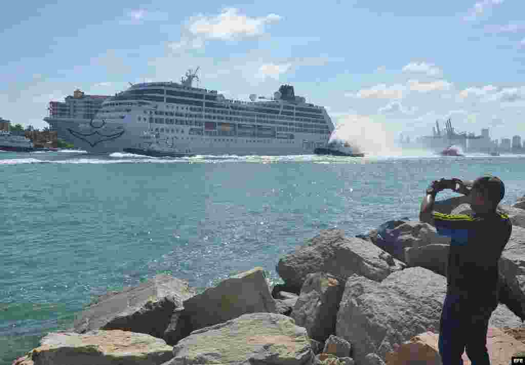 Un hombre toma desde tierra una fotografía a la embarcación de la compañía Fathom, filial de Carnival, el Adonia hoy, domingo 01 de mayo de 2016, en su viaje inaugural de 7 días a Cuba, en el puerto de Miami. 