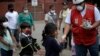 Voluntario de la Cruz Roja entrega alimentos a los niños migrantes hondureños