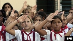 Archivo - Estudiantes saludan a la bandera en el primer día de clases.