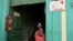 Una mujer contempla dos anuncios de negocios privados en Cuba (Foto: Archivo).