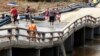 La gente cruza un puente afectado días después del paso del huracán Oscar en Guantánamo, Cuba, el 29 de octubre de 2024.