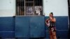 Una mujer fuma junto a una imagen de Fidel Castro. REUTERS/Alexandre Meneghini