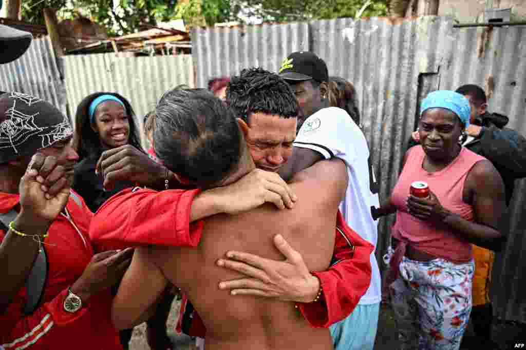 Marlon Brando Díaz (C), encarcelado por su participación en las protestas antigubernamentales de julio de 2021, saluda a sus familiares después de ser liberado de la prisión en el barrio de Guinera en La Habana el 16 de enero de 2025.  YAMIL LAGE / AFP