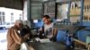 Un bodeguero vende productos racionados a un cliente en La Habana.
