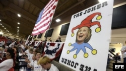 Vista de un cartel que representa a Hillary Clinton como la carta Joker es expuesto durante un evento de campaña de Donald Trump.
