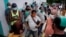 Personas esperan para comprar en un mercado mayorista en La Habana.